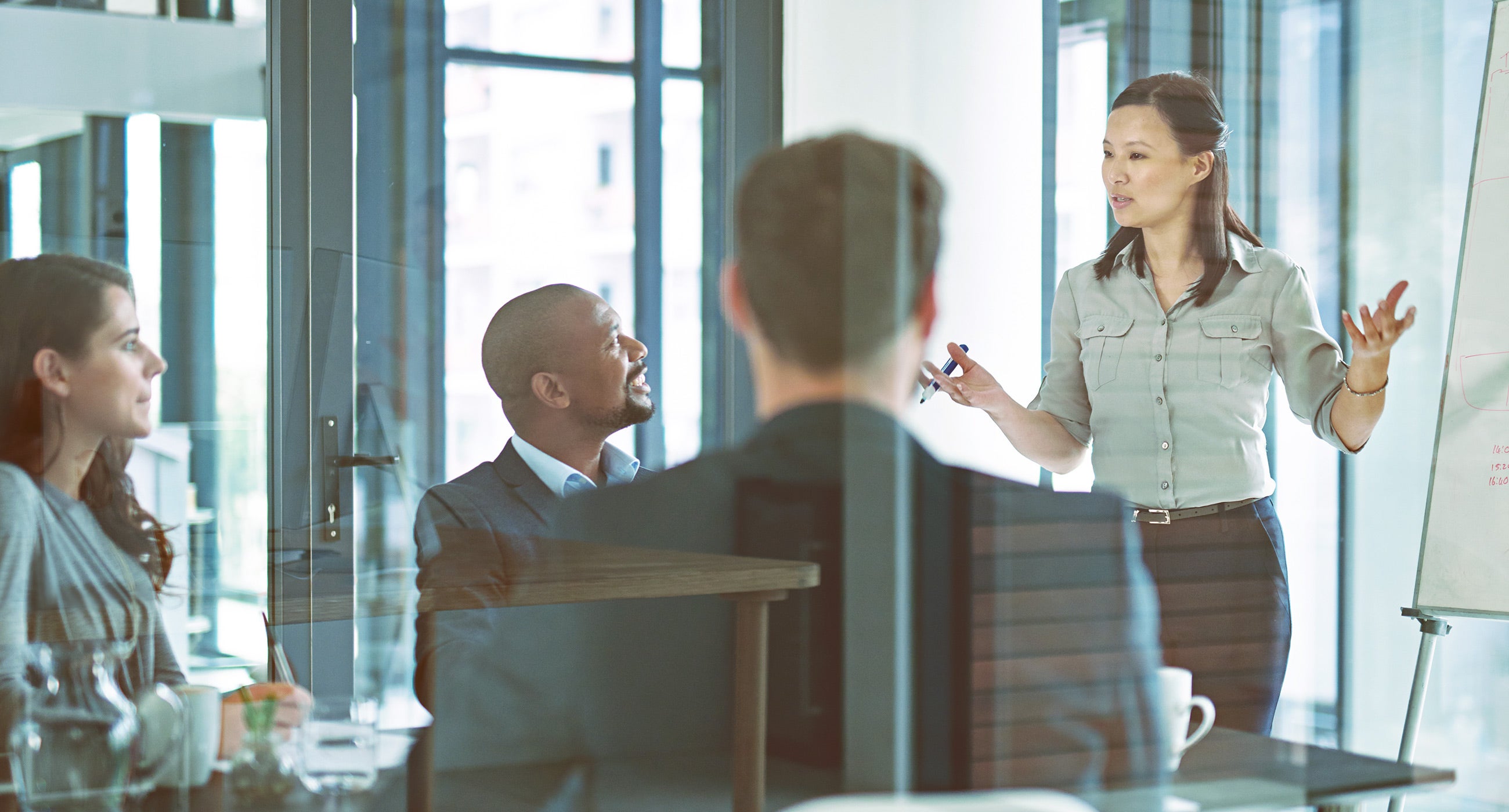 Woman presenting in a glass conference room