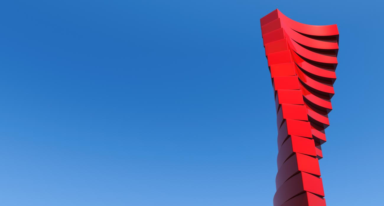 Red twisting sculpture against blue sky